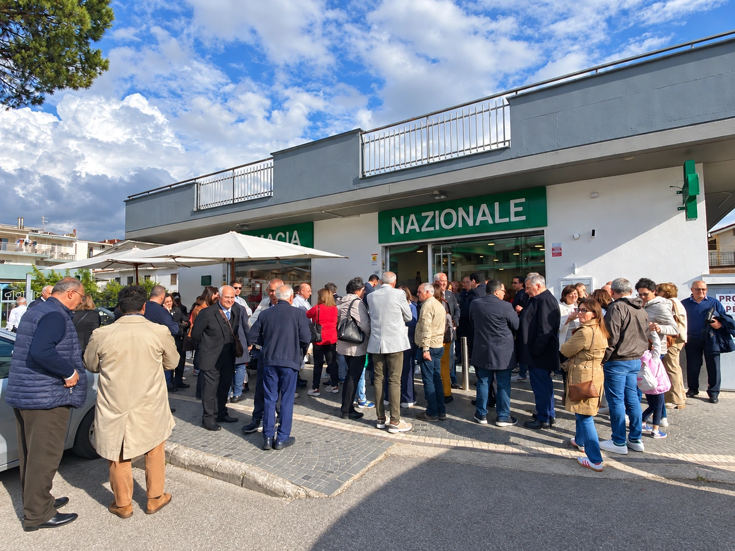 Persone riunite davanti all’ingresso della Farmacia Nazionale durante l’inaugurazione a San Vitaliano.