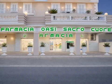Facciata della Farmacia OASI Sacro Cuore con insegna e accessi vetrati.