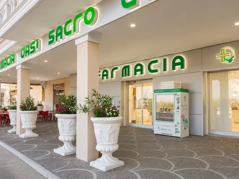 Ingresso della Farmacia OASI Sacro Cuore con insegna e vetrine illuminate.